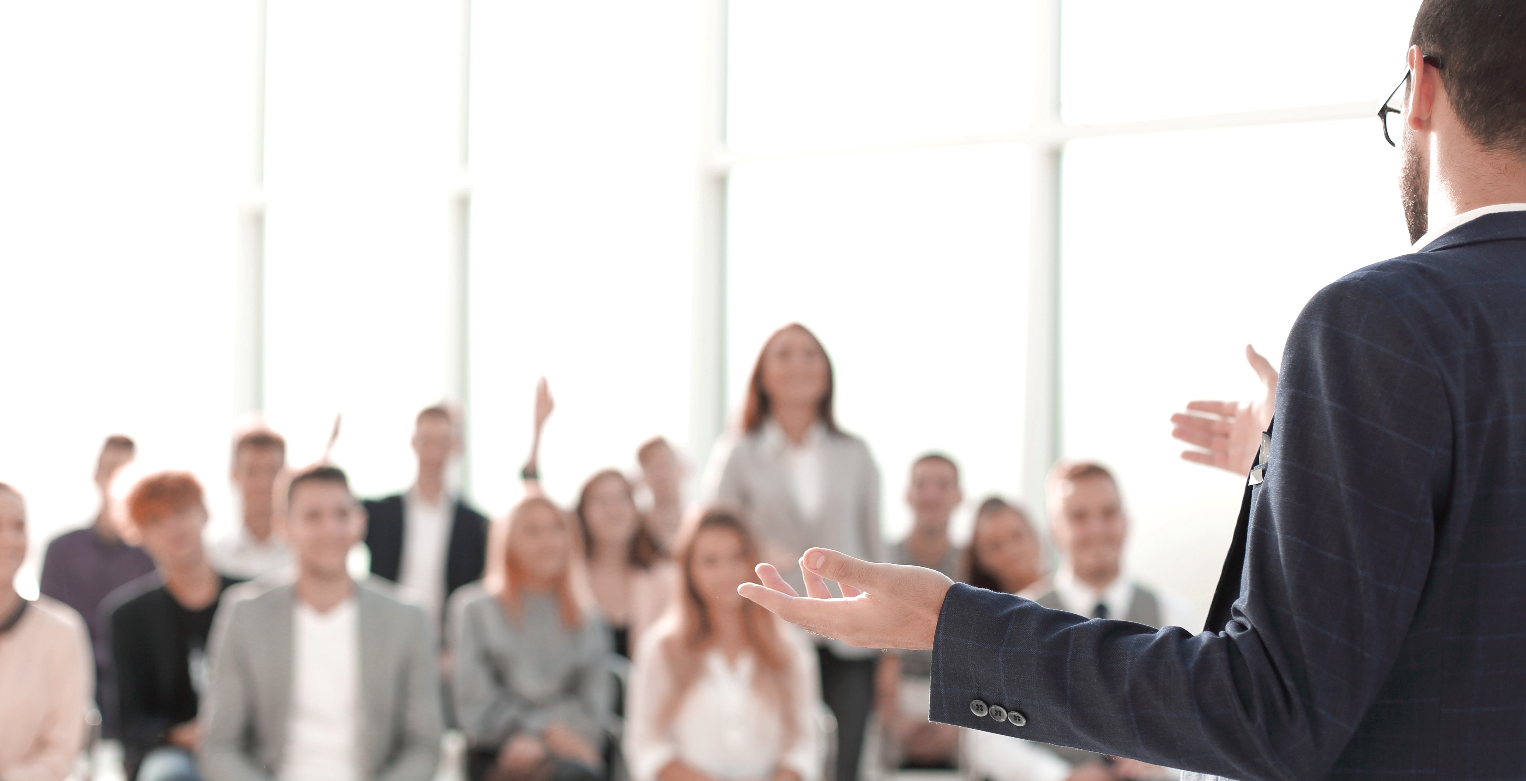 close-up-speaker-standing-front-audience-conference-room_(1).jpg